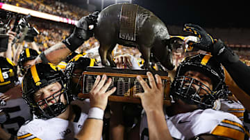 Sep 21, 2024; Minneapolis, Minnesota, USA; Iowa Hawkeyes offensive lineman Logan Jones (65) and defensive lineman Yahya Black (94) celebrate with the Floyd of Rosedale trophy after the game against the Minnesota Golden Gophers at Huntington Bank Stadium. Mandatory Credit: Matt Krohn-Imagn Images