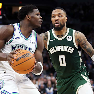 Feb 23, 2024; Minneapolis, Minnesota, USA; Minnesota Timberwolves guard Anthony Edwards (5) works around Milwaukee Bucks guard Damian Lillard (0)  during the second half at Target Center.