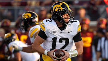 Sep 21, 2024; Minneapolis, Minnesota, USA; Iowa Hawkeyes quarterback Cade McNamara (12) takes a snap against the Minnesota Golden Gophers during the first half at Huntington Bank Stadium. Mandatory Credit: Matt Krohn-Imagn Images