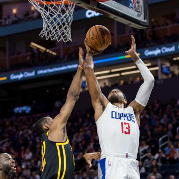 Feb 14, 2024; San Francisco, California, USA;  Golden State Warriors forward Jonathan Kuminga (00) defends against a shot by LA Clippers forward Paul George (13) during the second half at Chase Center. Mandatory Credit: John Hefti-USA TODAY Sports