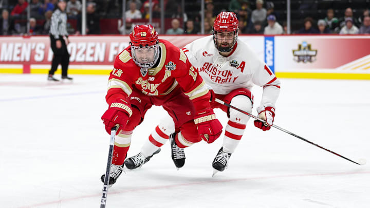 Apr 11, 2024; Saint Paul, Minnesota, USA; Denver Pioneers forward Massimo Rizzo (13) and Boston University Terriers forward Luke Tuch (11) compete for the puck during the third period in the semifinals of the 2024 Frozen Four college ice hockey tournament at Xcel Energy Center. Mandatory Credit: Matt Krohn-Imagn Images