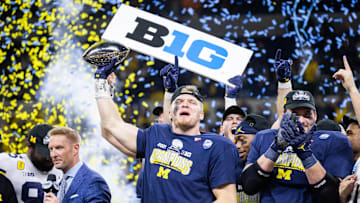 Dec 4, 2021; Indianapolis, IN, USA; Michigan Wolverines defensive end Aidan Hutchinson (97) lifts the Big Ten Championship Trophy after the game against the Iowa Hawkeyes  at Lucas Oil Stadium. Mandatory Credit: Trevor Ruszkowski-Imagn Images
