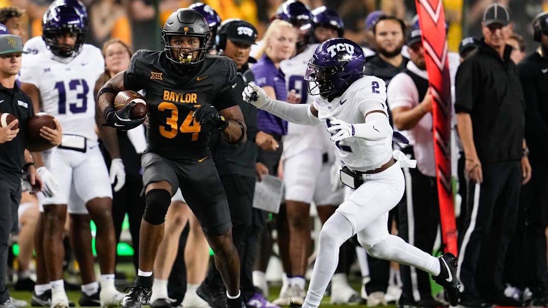 Nov 2, 2024; Waco, Texas, USA;  Baylor Bears wide receiver Josh Cameron (34) runs the ball after making a catch against TCU Horned Frogs safety Jamel Johnson (2) during the first half at McLane Stadium. Mandatory Credit: Chris Jones-Imagn Images