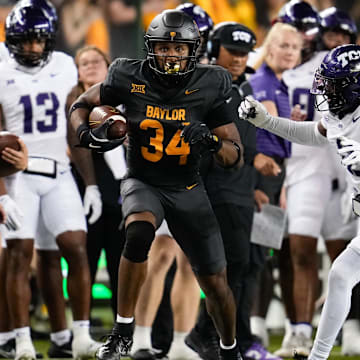 Nov 2, 2024; Waco, Texas, USA;  Baylor Bears wide receiver Josh Cameron (34) runs the ball after making a catch against TCU Horned Frogs safety Jamel Johnson (2) during the first half at McLane Stadium. Mandatory Credit: Chris Jones-Imagn Images