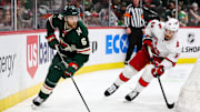 Feb 27, 2024; Saint Paul, Minnesota, USA; Minnesota Wild defenseman Dakota Mermis (6) skates with the puck alongside Carolina Hurricanes left wing Michael Bunting (58) during the second period at Xcel Energy Center. Mandatory Credit: Matt Krohn-Imagn Images
