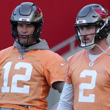 Nov 11, 2022; Munich, Germany; Tampa Bay Buccaneers quarterbacks Tom Brady (12) and Kyle Trask (2) react during practice at the FC Bayern Campus. Mandatory Credit: Kirby Lee-Imagn Images