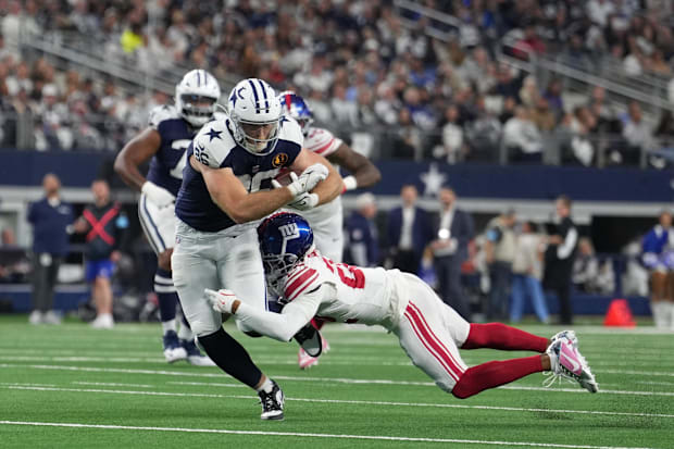 Dallas Cowboys tight end Luke Schoonmaker catches a pass as New York Giants cornerback Cor'Dale Flott attempts a tackle. 