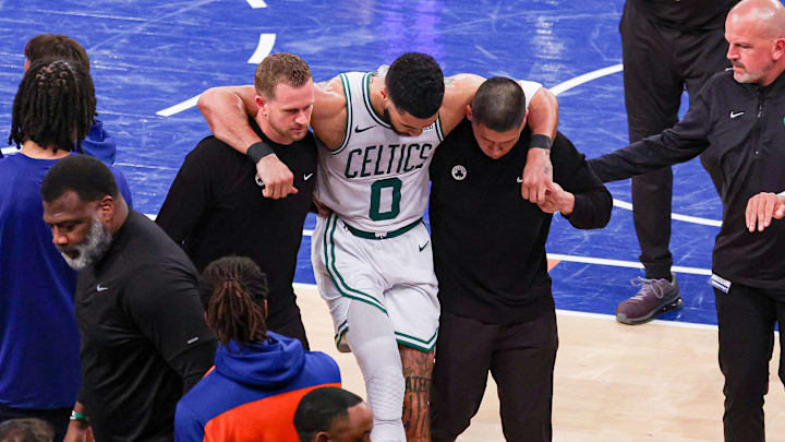 Boston Celtics forward Jayson Tatum helped off the court after an injury during the NBA Playoffs against the New York Knicks.