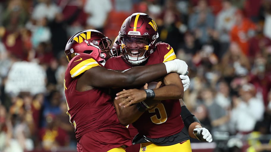 Washington Commanders quarterback Jayden Daniels celebrates with teammates after scoring a touchdown. | Amber Searls-Imagn Images