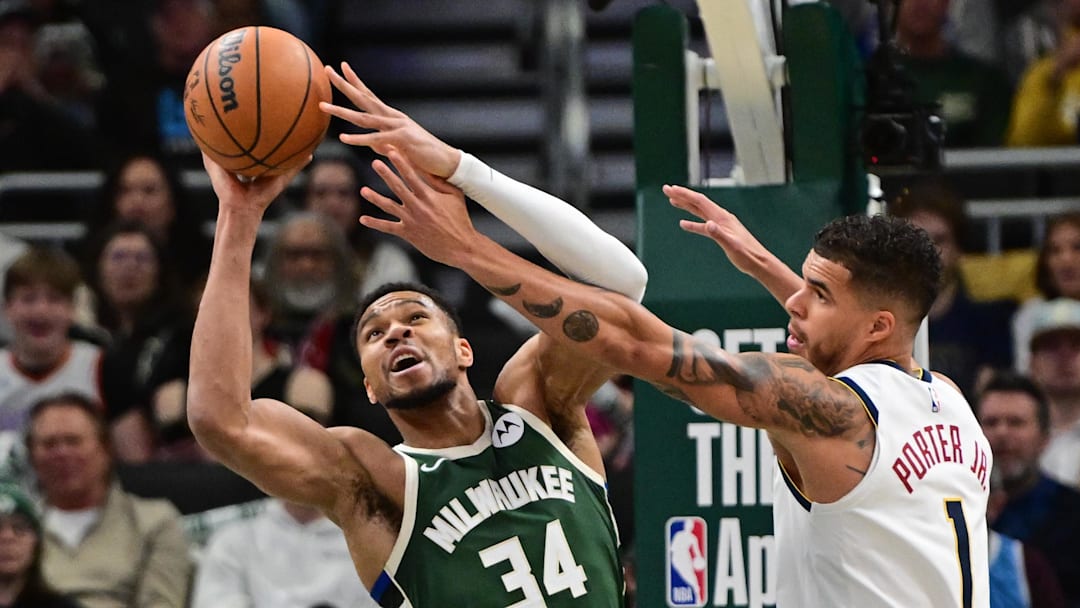 Feb 27, 2025; Milwaukee, Wisconsin, USA;  Milwaukee Bucks forward Giannis Antetokounmpo (34) grabs a rebound against Denver Nuggets forward Michael Porter Jr. (1) in the first quarter at Fiserv Forum. Mandatory Credit: Benny Sieu-Imagn Images