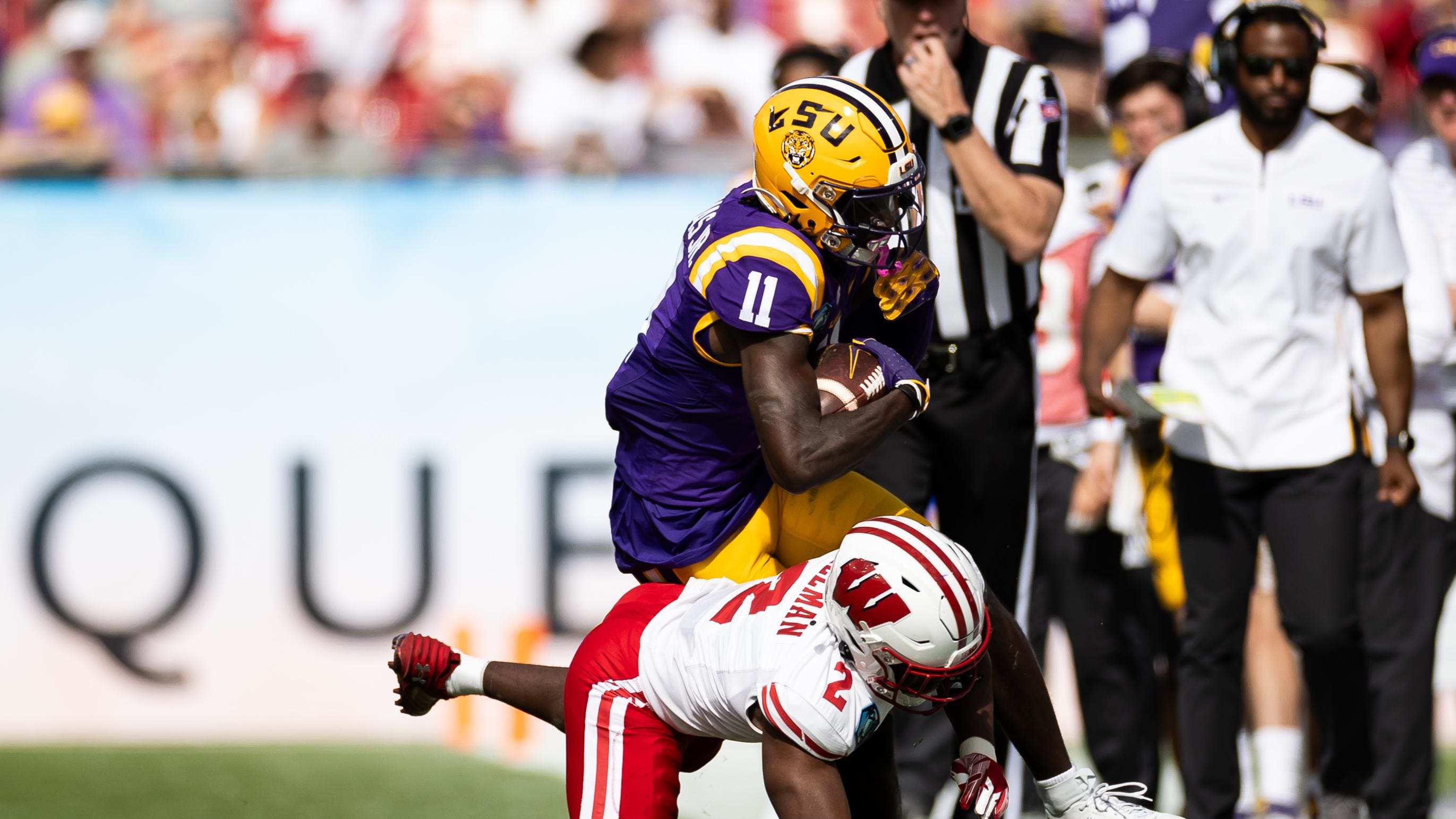 Wisconsin Badgers cornerback Ricardo Hallman (2) tackles LSU Tigers receiver Brian Thomas Jr.