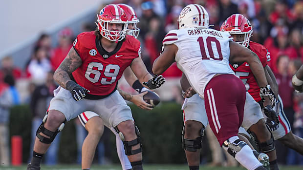 Tate Ratledge (red jersey) gets ready to block a defender.