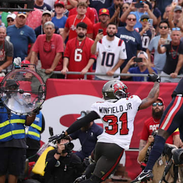 Nov 9, 2025; Tampa, Florida, USA; New England Patriots wide receiver Stefon Diggs (8) catches a touchdown pass under pressure from Tampa Bay Buccaneers safety Antoine Winfield Jr. (31) during the second quarter at Raymond James Stadium. Mandatory Credit: Nathan Ray Seebeck-Imagn Images