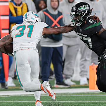 Nov 24, 2023; East Rutherford, New Jersey, USA; Miami Dolphins running back Raheem Mostert (31) is tackled by New York Jets linebacker C.J. Mosley (57) during the second half at MetLife Stadium. 