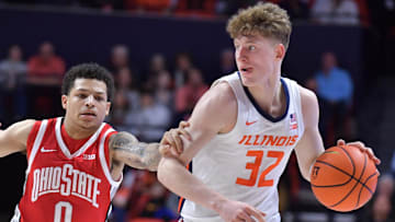 Feb 2, 2025; Champaign, Illinois, USA; Illinois Fighting Illini guard Kasparas Jakucionis (32) drives the ball past Ohio State Buckeyes guard John Mobley Jr. (0) during the first half at State Farm Center. Mandatory Credit: Ron Johnson-Imagn Images