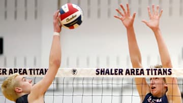 North Hills' Brady Davidson, left, attempts to push the volleyball past Shaler sophomore outsider hitter/right-side Krisztian Walker Monday night at Shaler High School. The Titans swept the Indians.