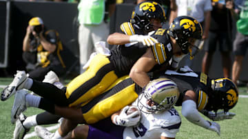 Iowa’s Xavier Nwankpa (1) tackles Washington Washington wide receiver Denzel Boston (12) with the help of two teammates Saturday, Oct. 12, 2024 at Kinnick Stadium in Iowa City, Iowa.