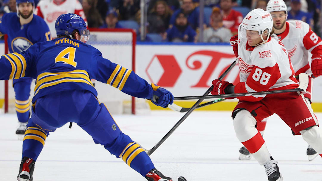 Mar 27, 2026; Buffalo, New York, USA;  Detroit Red Wings right wing Patrick Kane (88) tries to control the puck as Buffalo Sabres defenseman Bowen Byram (4) defends during the first period at KeyBank Center. Mandatory Credit: Timothy T. Ludwig-Imagn Images