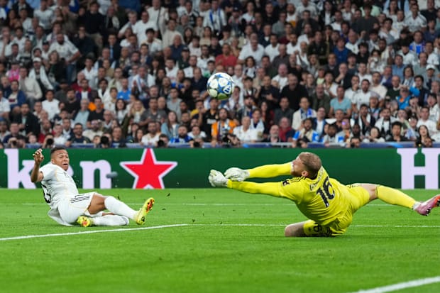 Michele Di Gregorio sprawling at full length to deny Kylian Mbappé