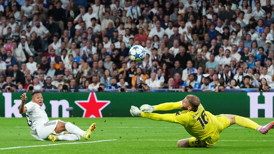 Michele Di Gregorio sprawling at full length to deny Kylian Mbappé