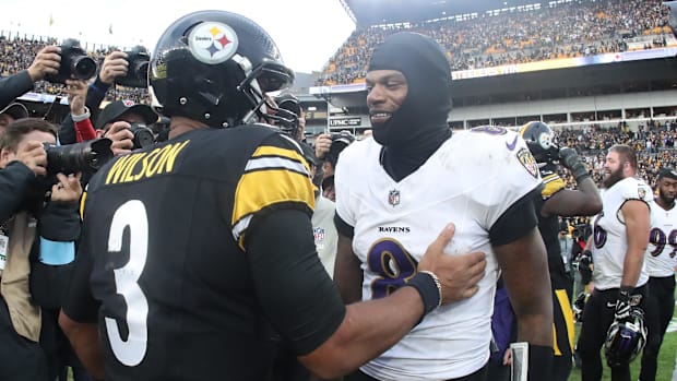 Pittsburgh Steelers quarterback Russell Wilson and Baltimore Ravens quarterback Lamar Jackson meet at mid-field after a game.