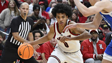 Nov 11, 2025; Louisville, Kentucky, USA;  Louisville Cardinals guard Mikel Brown Jr. (0) dribbles against Kentucky Wildcats forward Andrija Jelavic (4) during the second half at KFC Yum! Center. Louisville defeated Kentucky 96-88. Mandatory Credit: Jamie Rhodes-Imagn Images