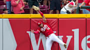 Cincinnati Reds third baseman Noelvi Marte (16) leaps to rob a home run over the wall from Pittsburgh Pirates right fielder Bryan Reynolds (10) in the ninth inning of the MLB National League game between the Cincinnati Reds and the Pittsburgh Pirates at Great American Ball Park in downtown Cincinnati on Thursday, Sept. 25, 2025. The Reds won, 2-1.