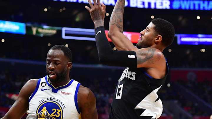 Mar 15, 2023; Los Angeles, California, USA; Los Angeles Clippers forward Paul George (13) shoots against Golden State Warriors forward Draymond Green (23) during the second half at Crypto.com Arena. 