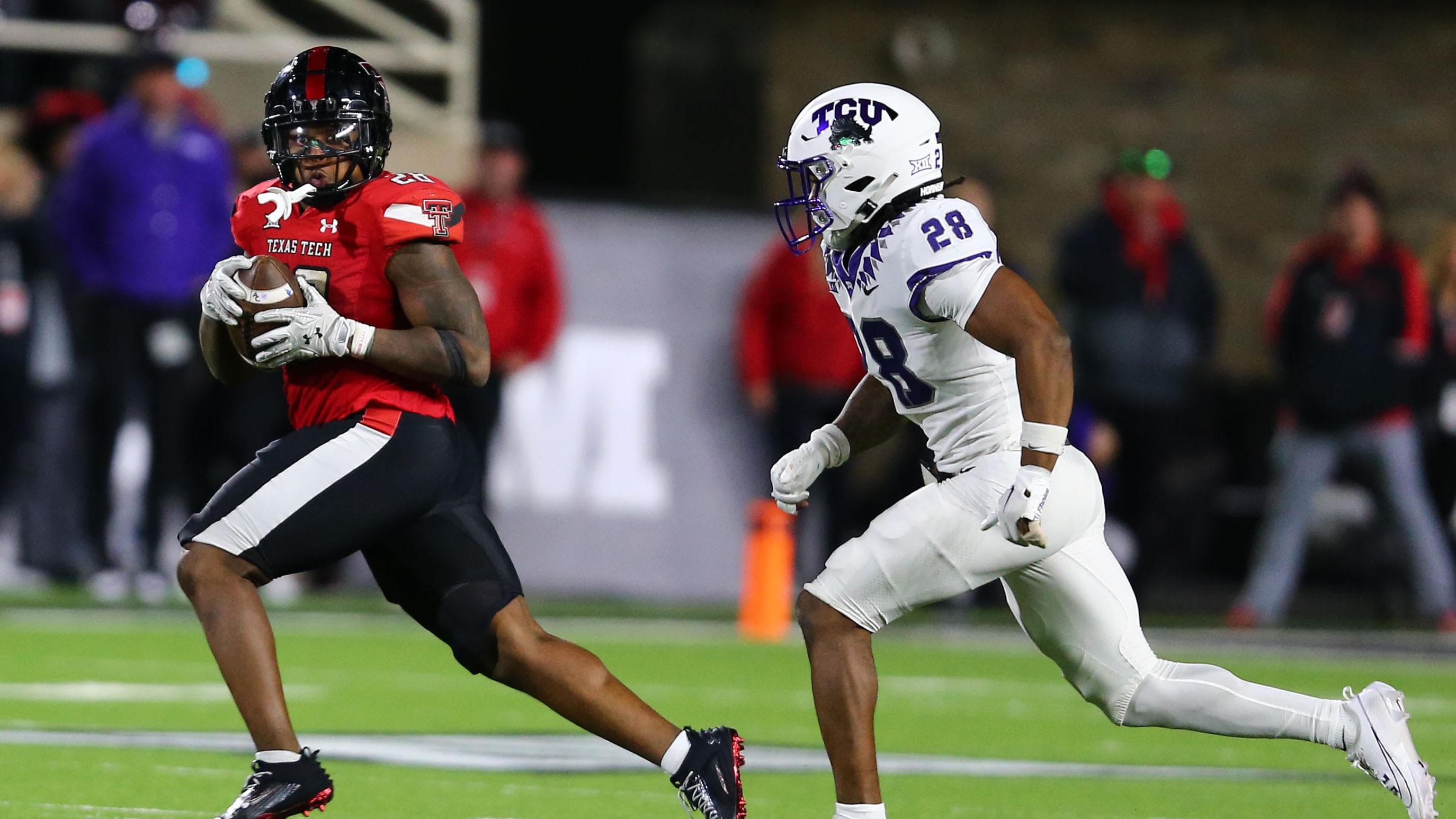 Texas Tech Red Raiders running back Tahj Brooks (28) rushes while being chased by TCU defender Millard Bradford.