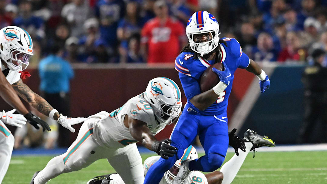 Buffalo Bills running back James Cook (4) runs against Miami Dolphins linebacker Jordyn Brooks (20) in the first half at Highmark Stadium.