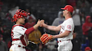 Angels relief pitcher Mike Mayers (21) and catcher Max Stassi (33) celebrate defeating Cleveland Guardians at Angel Stadium on April 27, 2022.