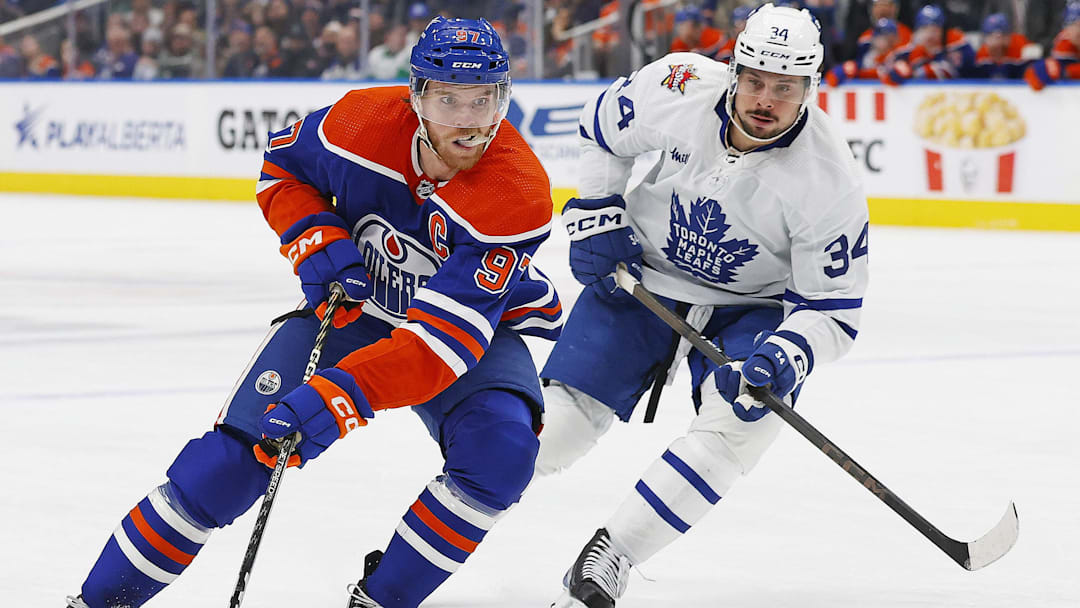 Jan 16, 2024; Edmonton, Alberta, CAN; Edmonton Oilers forward Connor McDavid (97) carries the puck around Toronto Maple Leafs forward Auston Matthews (34) during the first period at Rogers Place. Mandatory Credit: Perry Nelson-Imagn Images