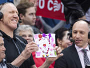Pac-12 basketball analyst Bill Walton and announcer Dave Pasch hold up drawings for the camera during a game between the Arizona Wildcats and Washington Huskies in 2019.