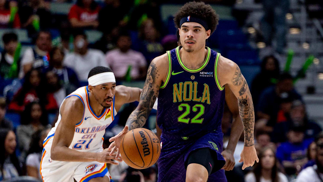 Apr 13, 2025; New Orleans, Louisiana, USA;  New Orleans Pelicans guard Lester Quinones (22) dribbles against Oklahoma City Thunder guard Aaron Wiggins (21) during the second half at Smoothie King Center. Mandatory Credit: Stephen Lew-Imagn Images