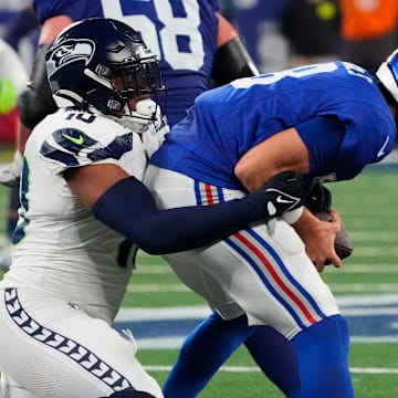 Oct 2, 2023; East Rutherford, New Jersey, USA; New York Giants quarterback Daniel Jones (8) is sacked by Seattle Seahawks linebacker Uchenna Nwosu (10) in the second half at MetLife Stadium. Mandatory Credit: Robert Deutsch-Imagn Images