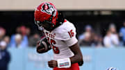 Nov 30, 2024; Chapel Hill, North Carolina, USA; North Carolina State Wolfpack quarterback CJ Bailey (16) is pushed out of bounds by North Carolina Tar Heels defensive back Alijah Huzzie (28) in the first quarter at Kenan Memorial Stadium. Mandatory Credit: Bob Donnan-Imagn Images