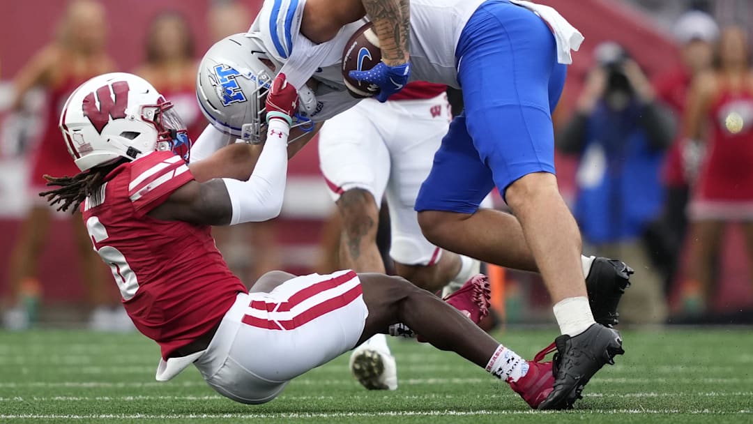 Sep 6, 2025; Madison, Wisconsin, USA; Wisconsin Badgers’ Omillio Agard tackles Middle Tennessee Blue Raiders tight end Hunter Tipton (82) during the second half at Camp Randall Stadium.