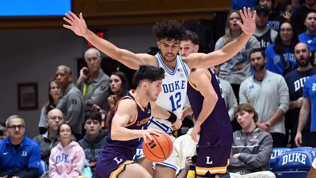 Dec 16, 2025; Durham, North Carolina, USA; Lipscomb Bisons guard Mateo Esmeraldo (1) drives to the basket as Duke Blue Devils forward Cameron Boozer (12) defends during the first half at Cameron Indoor Stadium. Mandatory Credit: Rob Kinnan-Imagn Images