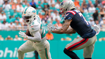 Miami Dolphins running back De'Von Achane (28) runs with the football against New England Patriots cornerback Carlton Davis III (7) during the third quarter at Hard Rock Stadium.