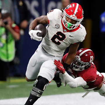 Georgia running back Kendall Milton (2) avoids a tackle from Alabama defensive back Malachi Moore (13) during the second half of the SEC Championship game against Alabama at Mercedes-Benz Stadium in Atlanta, on Saturday, Dec. 2, 2023. Alabama won 27-24.