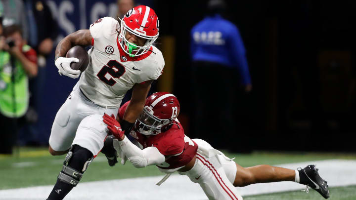 Georgia running back Kendall Milton (2) avoids a tackle from Alabama defensive back Malachi Moore (13) during the second half of the SEC Championship game against Alabama at Mercedes-Benz Stadium in Atlanta, on Saturday, Dec. 2, 2023. Alabama won 27-24.