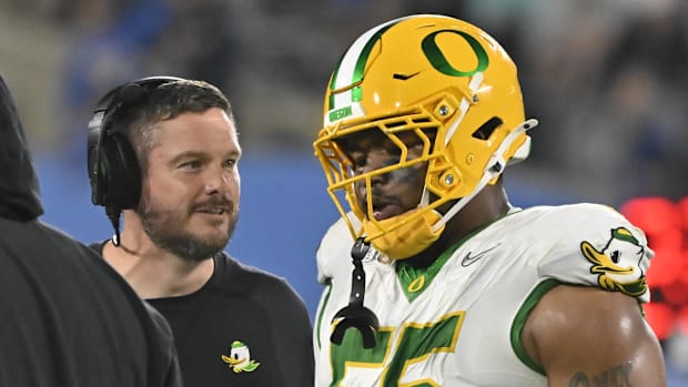 Oregon Ducks head coach Dan Lanning talks to Oregon Ducks defensive lineman Derrick Harmon