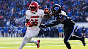 Nov 30, 2024; Lexington, Kentucky, USA; Louisville Cardinals running back Isaac Brown (25) runs the ball against Kentucky Wildcats defensive back Alex Afari Jr. (3) during the first quarter at Kroger Field. Mandatory Credit: Jordan Prather-Imagn Images