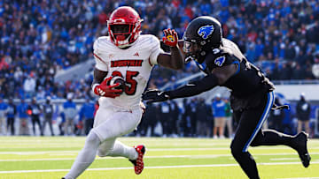 Nov 30, 2024; Lexington, Kentucky, USA; Louisville Cardinals running back Isaac Brown (25) runs the ball against Kentucky Wildcats defensive back Alex Afari Jr. (3) during the first quarter at Kroger Field. Mandatory Credit: Jordan Prather-Imagn Images