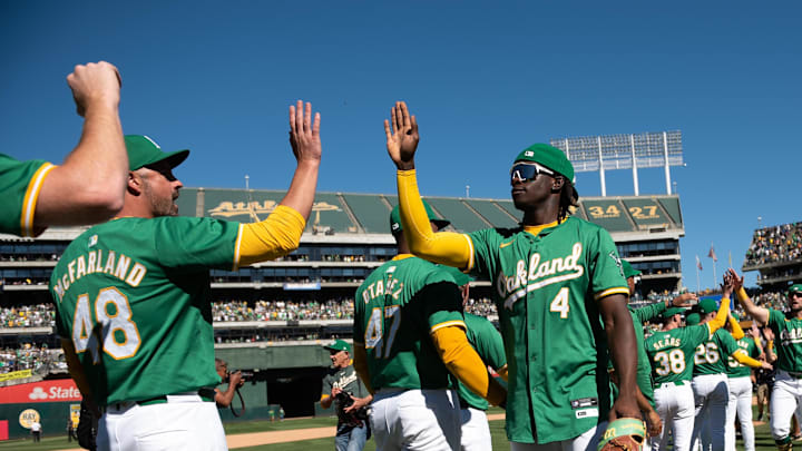  Oakland Athletics pitcher T.J. McFarland (48) high fives outfielder Lawrence Butler (4) in a 2024 game.