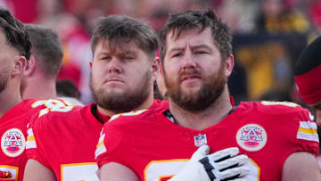 Nov 29, 2024; Kansas City, Missouri, USA; Kansas City Chiefs tight end Travis Kelce (87) and center Creed Humphrey (52) and guard Joe Thuney (62) stand for the national anthem prior to a game against the Las Vegas Raiders at GEHA Field at Arrowhead Stadium. Mandatory Credit: Denny Medley-Imagn Images