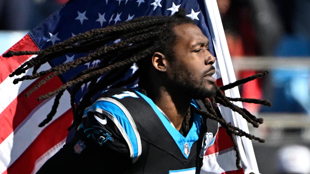 Nov 24, 2024; Charlotte, North Carolina, USA; Carolina Panthers linebacker Jadeveon Clowney (7) runs on to the field with the american flag before the game at Bank of America Stadium. Mandatory Credit: Bob Donnan-Imagn Images