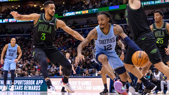 Dec 26, 2023; New Orleans, Louisiana, USA; Memphis Grizzlies guard Ja Morant (12) dribbles against New Orleans Pelicans guard CJ McCollum (3) during the second half at Smoothie King Center. Mandatory Credit: Stephen Lew-USA TODAY Sports