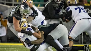 Oregon outside linebackers Matayo Uiagalelei, right, and Teitum Tuioti, left, sack Washington quarterback Demond Williams Jr.  The Ducks had 40 sacks last season, good for 14th in the country: Good, not great.