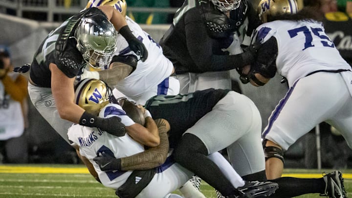 Oregon outside linebackers Matayo Uiagalelei, right, and Teitum Tuioti, left, sack Washington quarterback Demond Williams Jr. as the No. 1 Oregon Ducks host the Washington Huskies Saturday, Nov. 30, 2024 at Autzen Stadium in Eugene, Ore.
